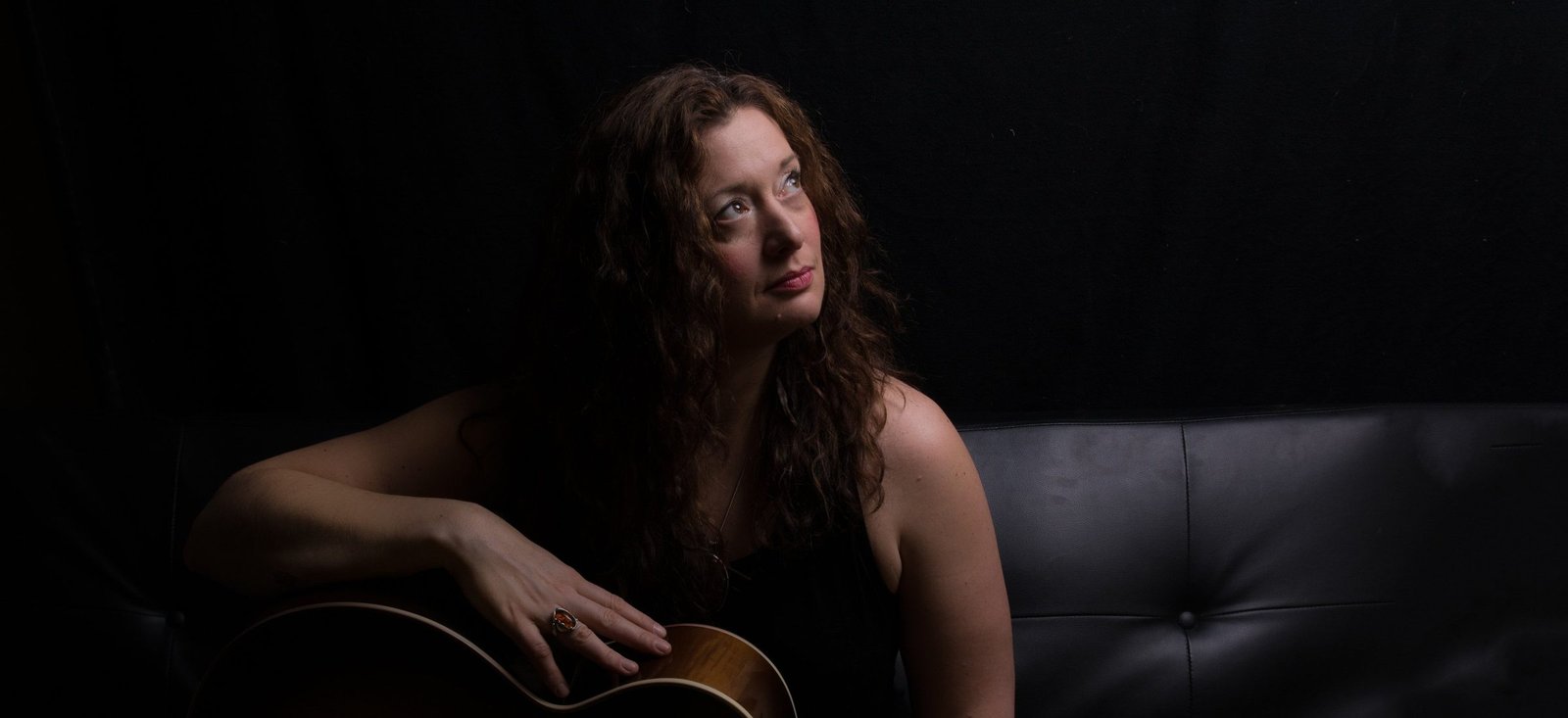 Lindsay May seated with her guitar